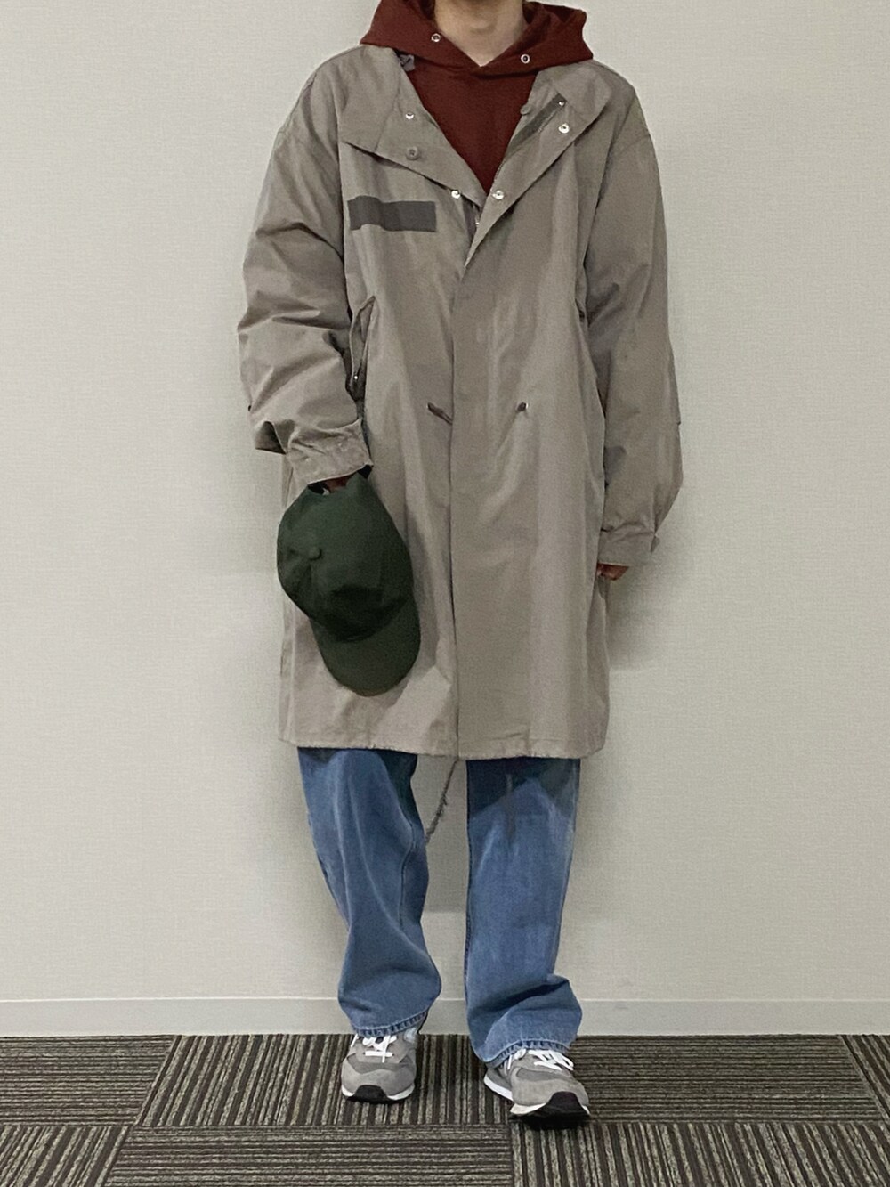 ブラウン系のパーカー、ベージュ系のその他アウター、ブルー系のデニムパンツを着用したメンズの冬コーディネートの3枚目の写真