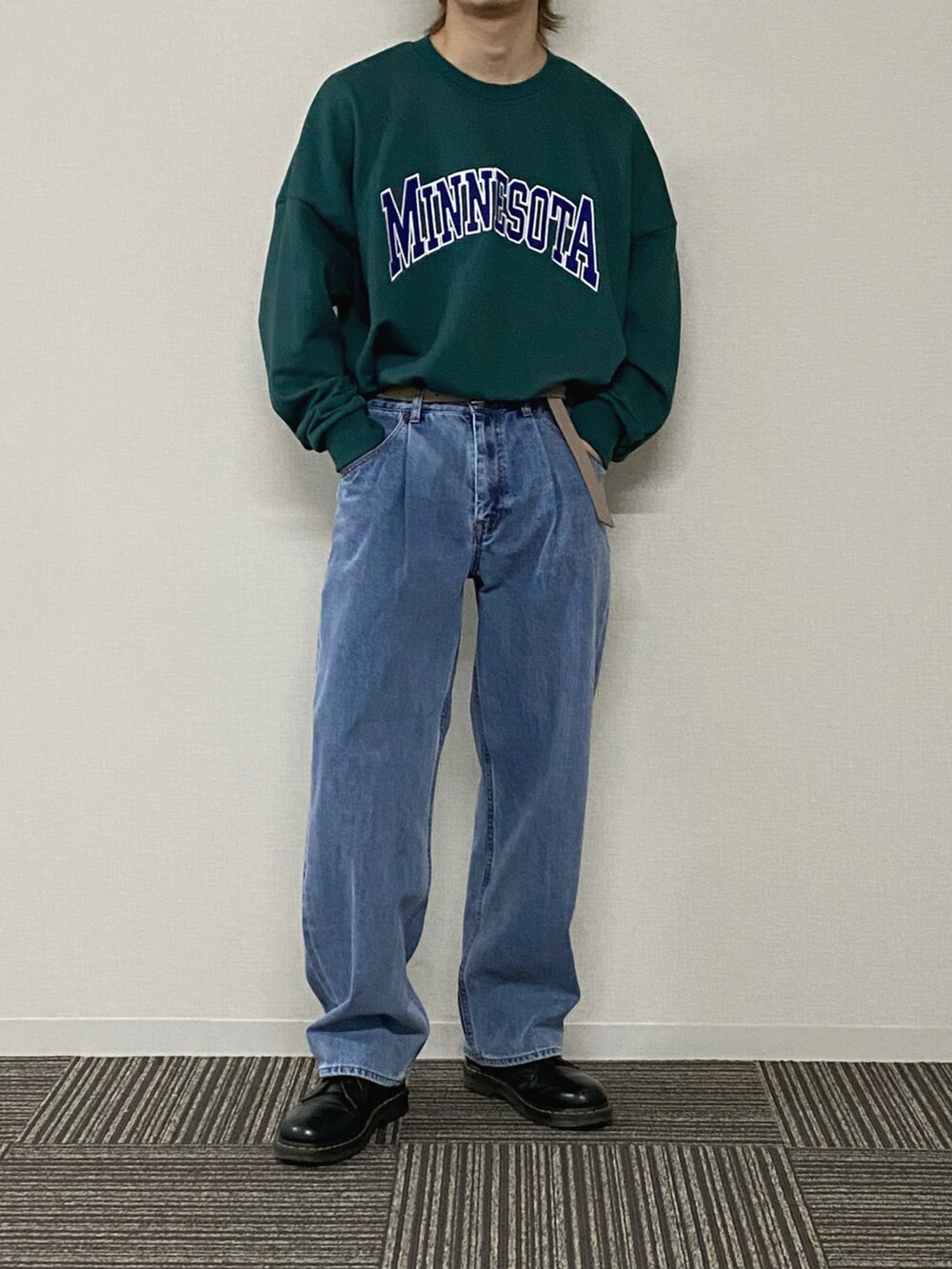 グレー系のブルゾン、グリーン系のスウェット、ブルー系のデニムパンツを着用したメンズの冬コーディネートの2枚目の写真