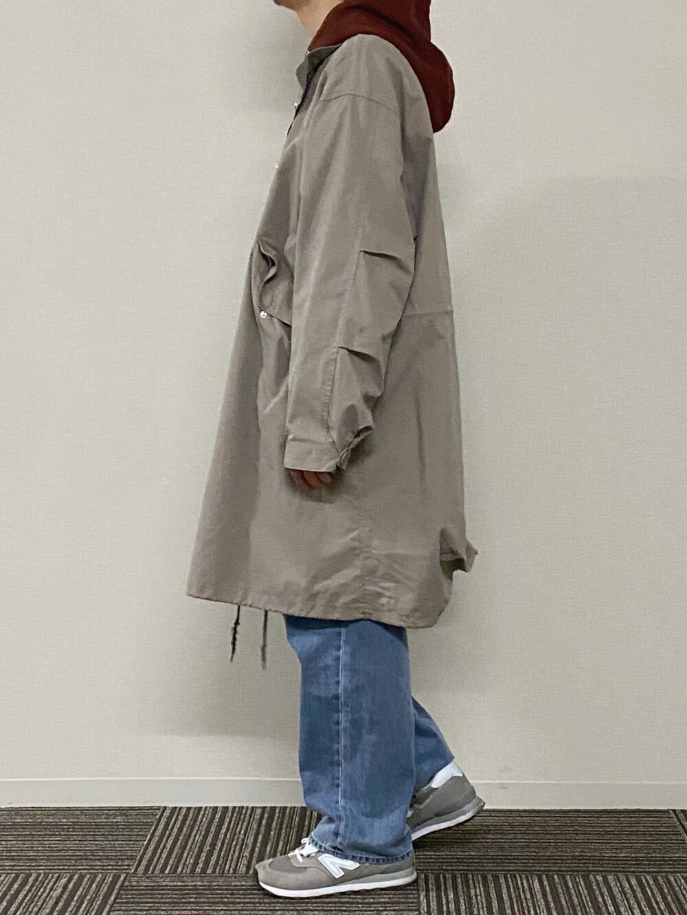 ブラウン系のパーカー、ベージュ系のその他アウター、ブルー系のデニムパンツを着用したメンズの冬コーディネートの4枚目の写真