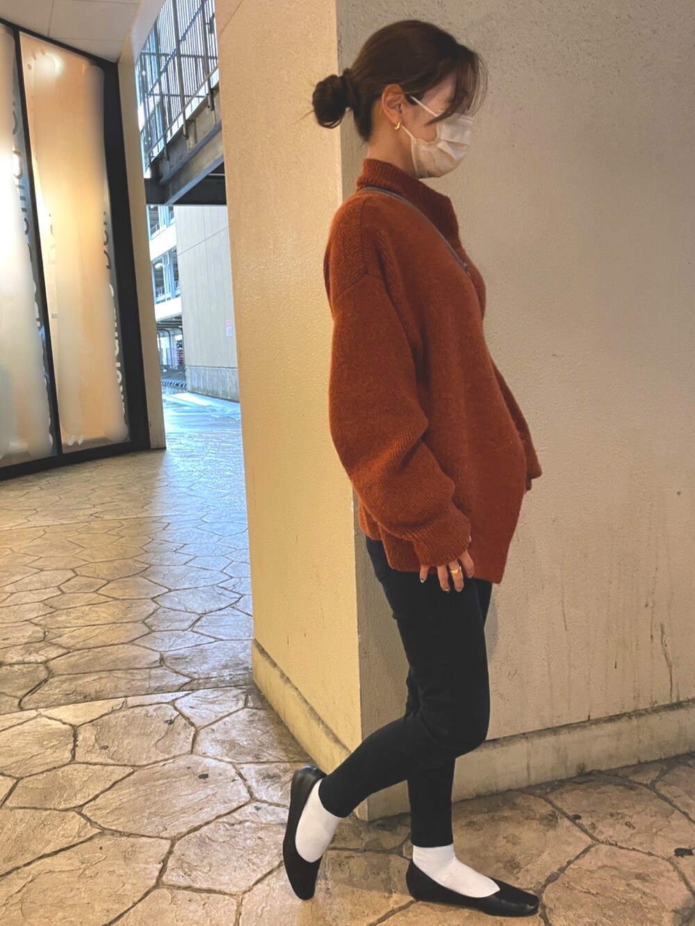 オレンジ系のニット/セーター、ブラック系のデニムパンツ、ブラック系のパンプスを着用したレディースの冬コーディネートの2枚目の写真