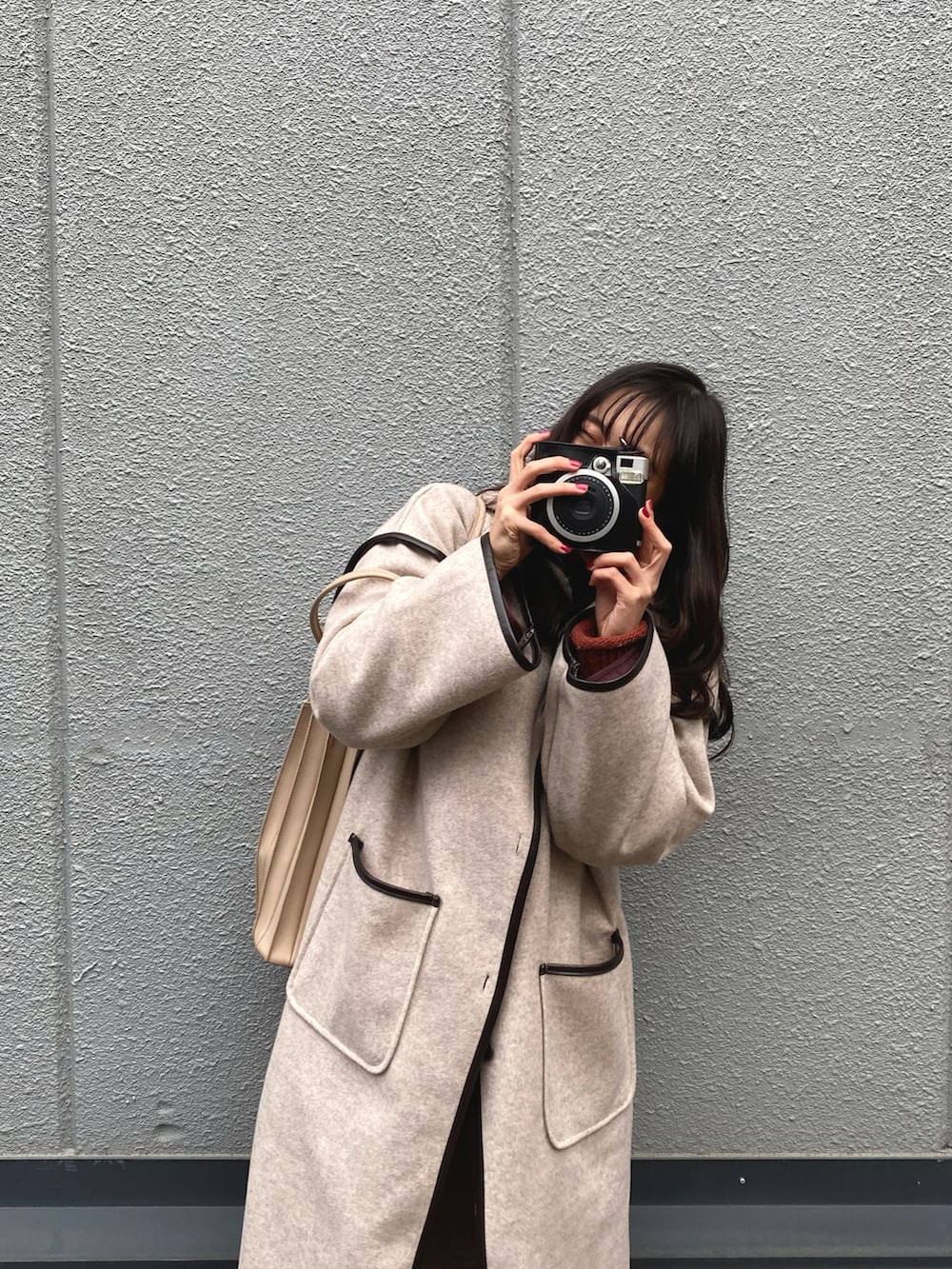 ベージュ系のその他アウター、ホワイト系のトートバッグ、オレンジ系のニット/セーターを着用したレディースの冬コーディネートの2枚目の写真