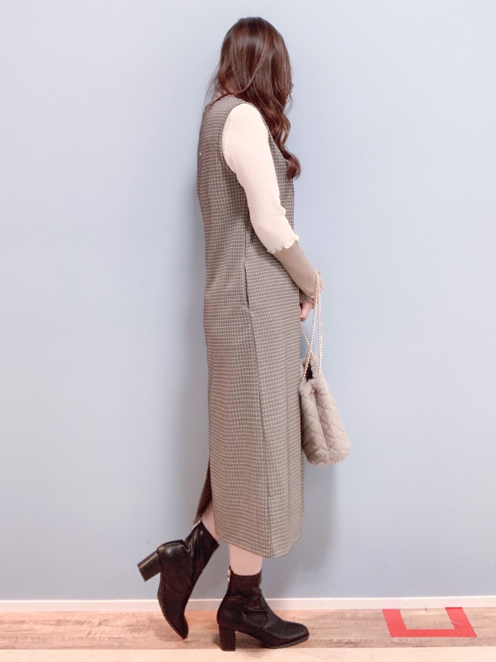 ベージュ系のワンピース、ベージュ系のショルダーバッグ、ブラック系のブーツを着用したレディースの秋コーディネートの2枚目の写真