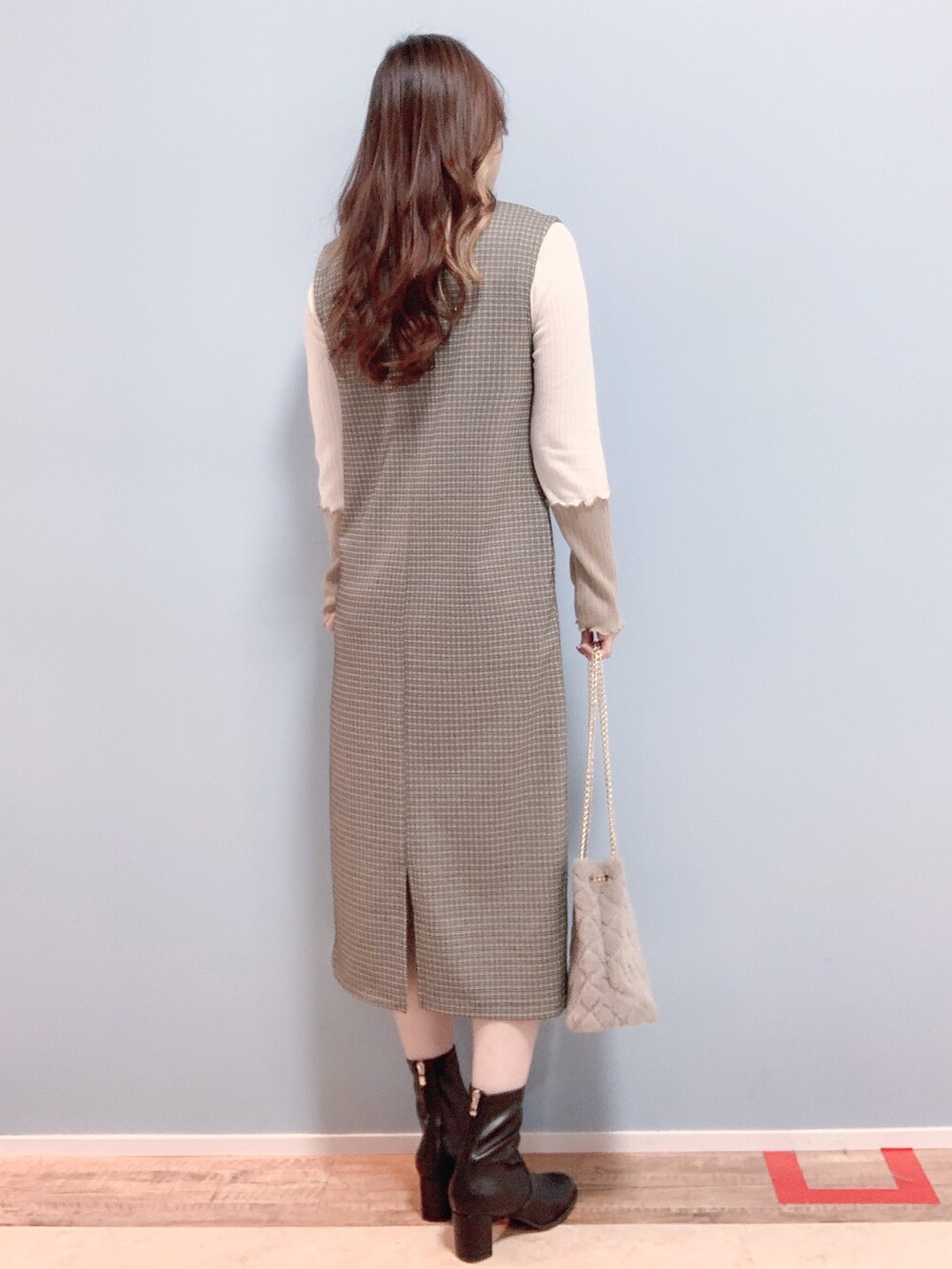 ベージュ系のワンピース、ベージュ系のショルダーバッグ、ブラック系のブーツを着用したレディースの秋コーディネートの3枚目の写真