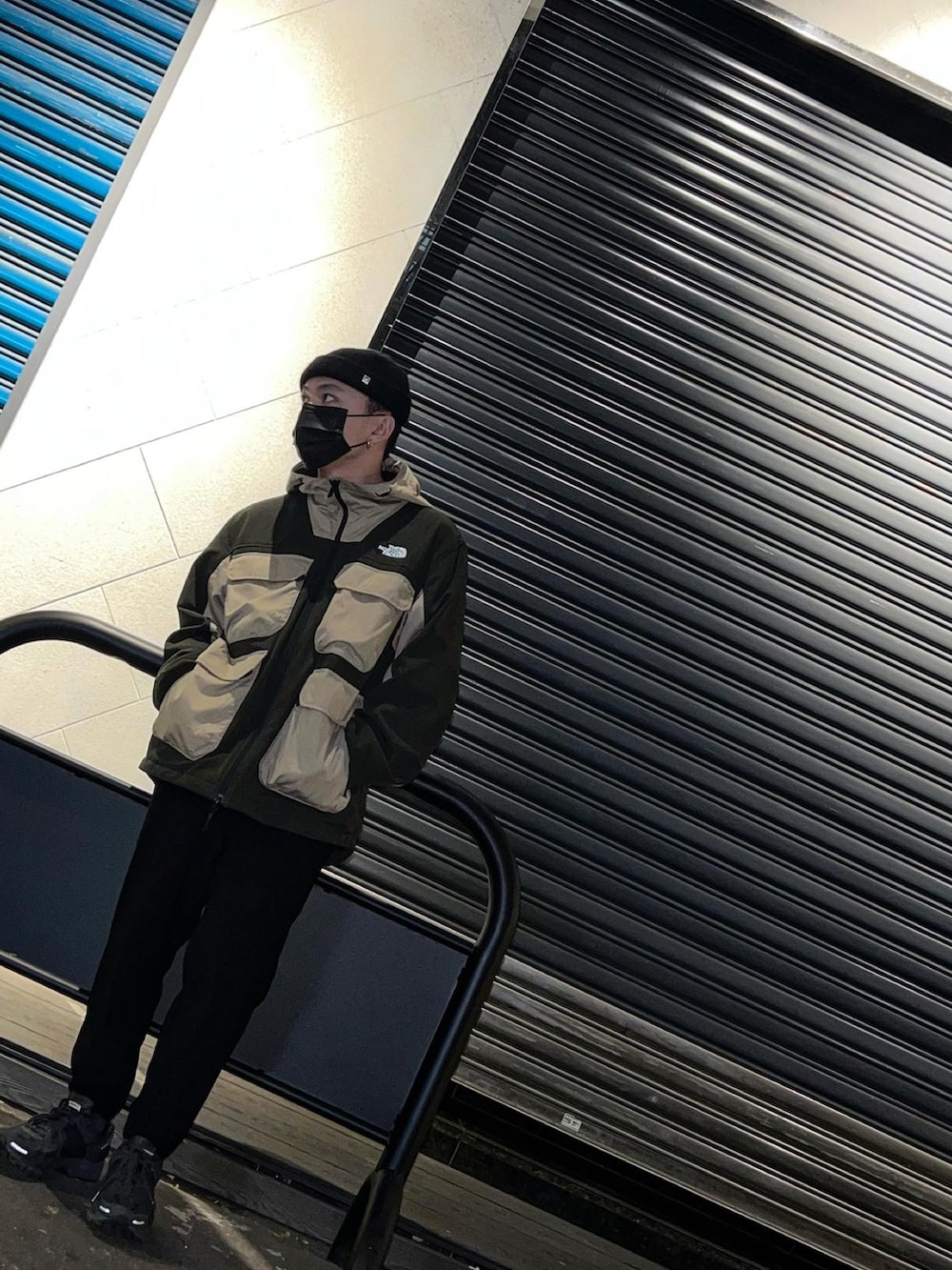 ブラック系のマウンテンパーカー、ホワイト系のニットキャップ/ビーニーを着用したメンズの冬コーディネートの2枚目の写真