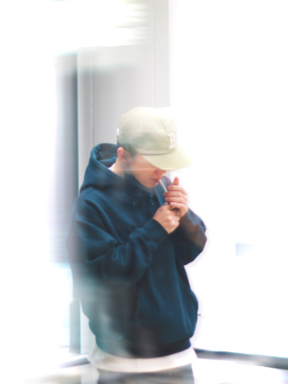 ブラック系のパーカー、その他のキャップ、シルバー系のリングを着用したメンズの春コーディネートの2枚目の写真