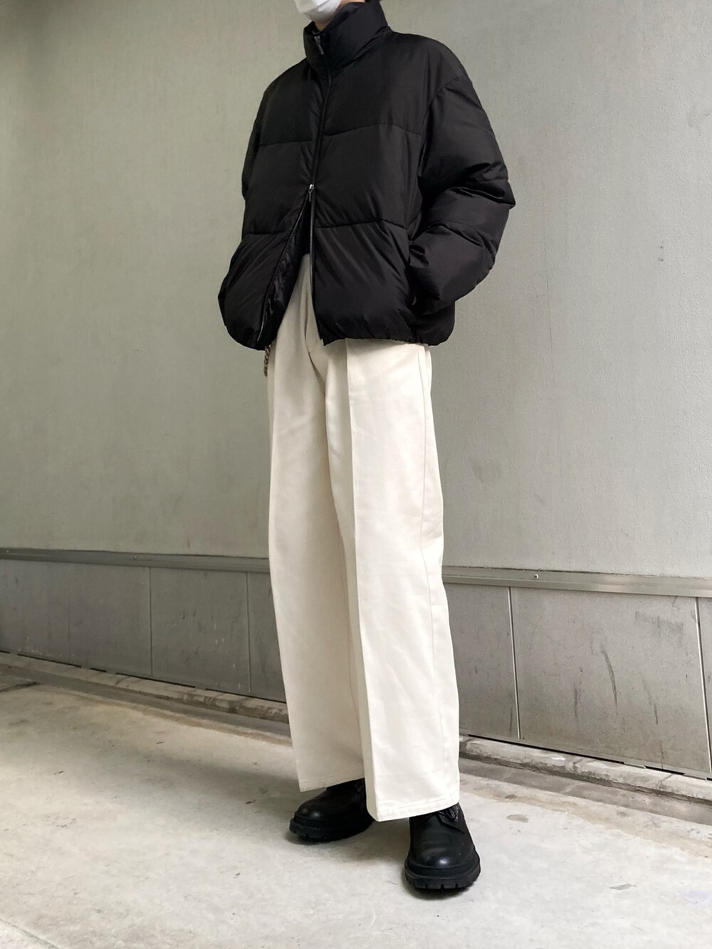 ブラック系のダウンジャケット/コート、グレー系のTシャツ/カットソー、ホワイト系のデニムパンツを着用したメンズの冬コーディネートの2枚目の写真