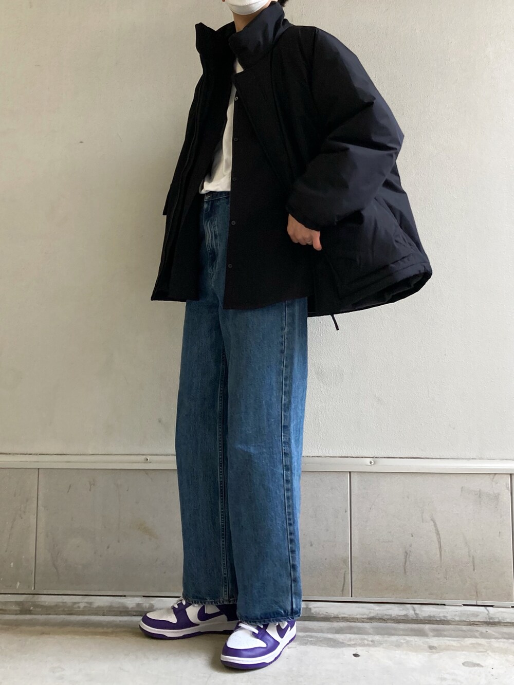 グレー系のTシャツ/カットソー、ブラック系のダウンジャケット/コート、ブルー系のデニムパンツを着用したメンズの春コーディネートの3枚目の写真