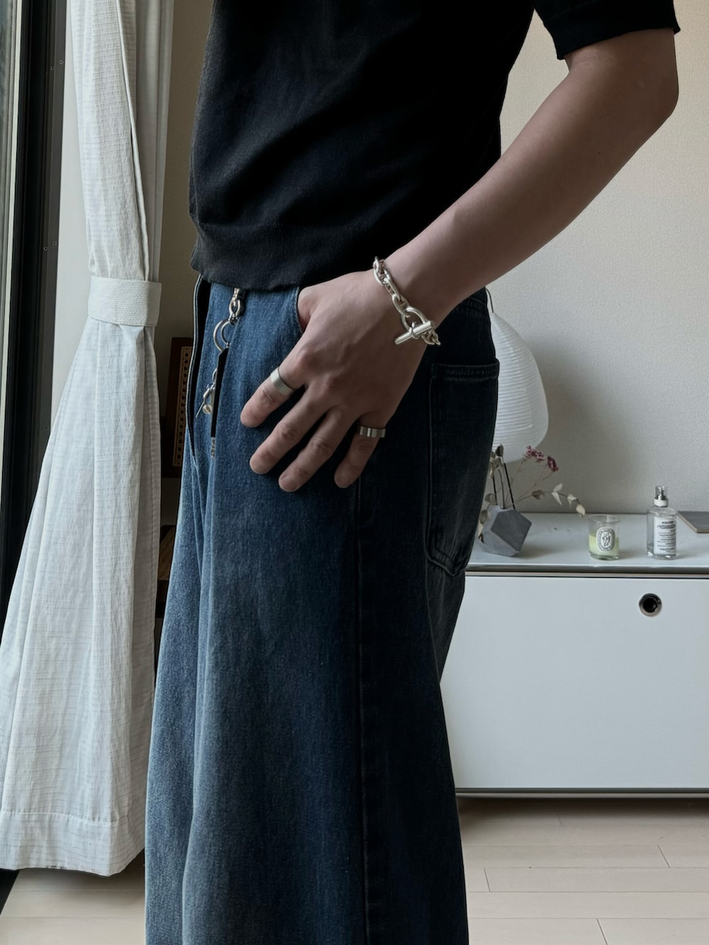 グレー系のスラックス、ブラック系のTシャツ/カットソー、シルバー系のリングを着用したメンズの夏コーディネートの2枚目の写真