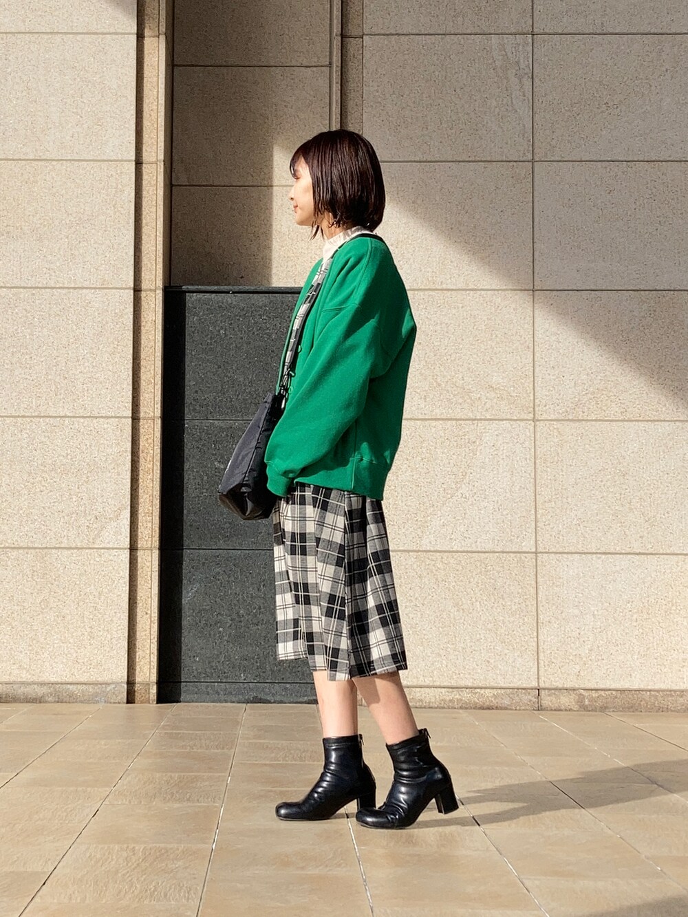 ホワイト系のワンピース、グリーン系のカーディガン/ボレロ、ブラック系のブーツを着用したレディースの冬コーディネートの3枚目の写真