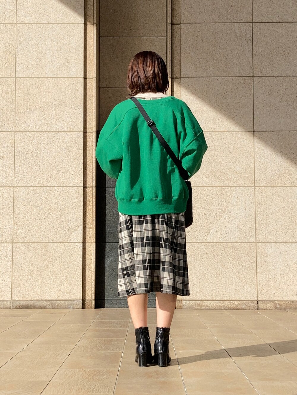 ホワイト系のワンピース、グリーン系のカーディガン/ボレロ、ブラック系のブーツを着用したレディースの冬コーディネートの4枚目の写真