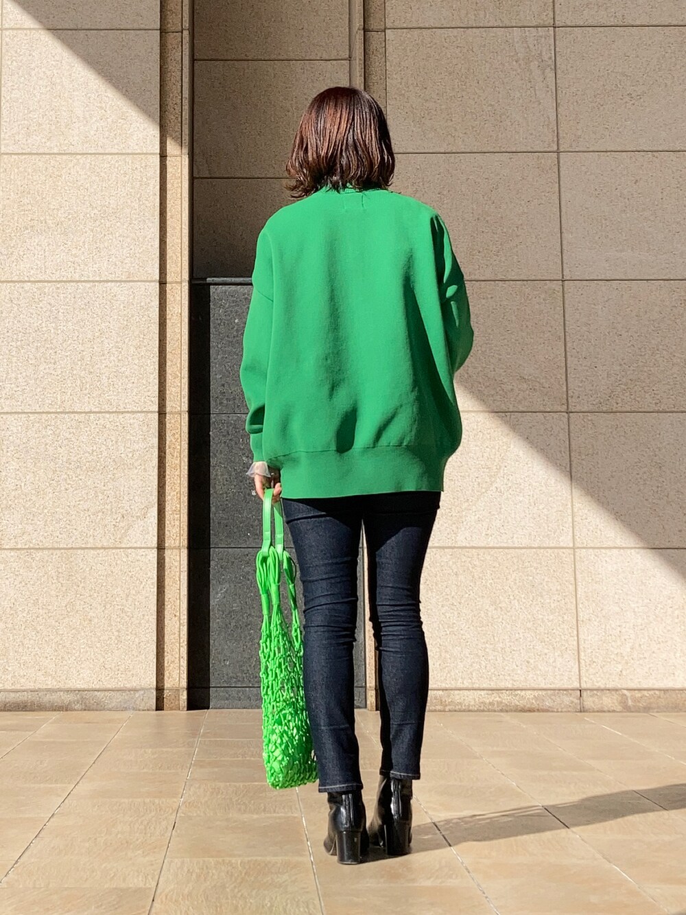 グリーン系のカーディガン/ボレロ、ブルー系のTシャツ/カットソー、グリーン系のトートバッグを着用したレディースの冬コーディネートの3枚目の写真