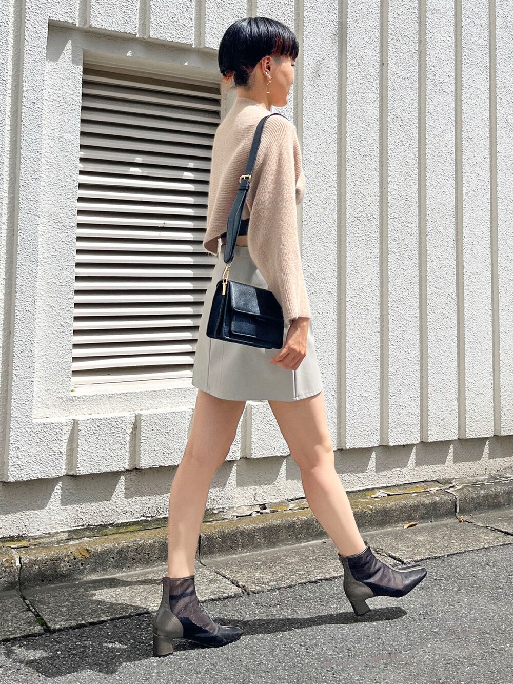 ベージュ系のニット/セーター、ブラック系のキャミソール、ブラック系のショルダーバッグを着用したレディースの秋コーディネートの2枚目の写真