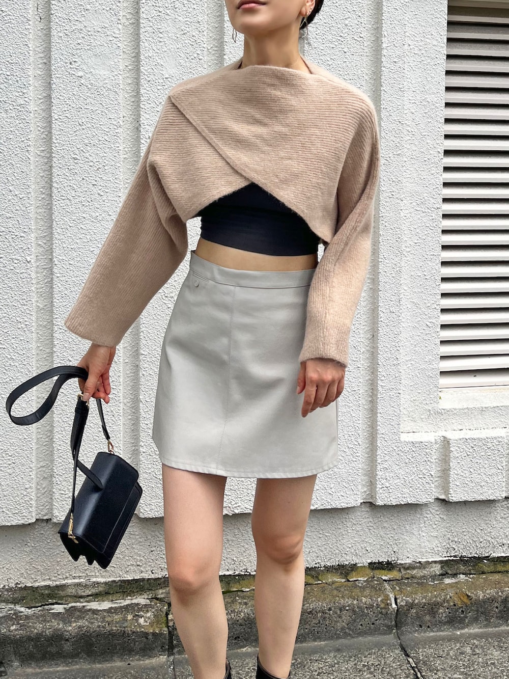 ベージュ系のニット/セーター、ブラック系のキャミソール、ブラック系のショルダーバッグを着用したレディースの秋コーディネートの3枚目の写真