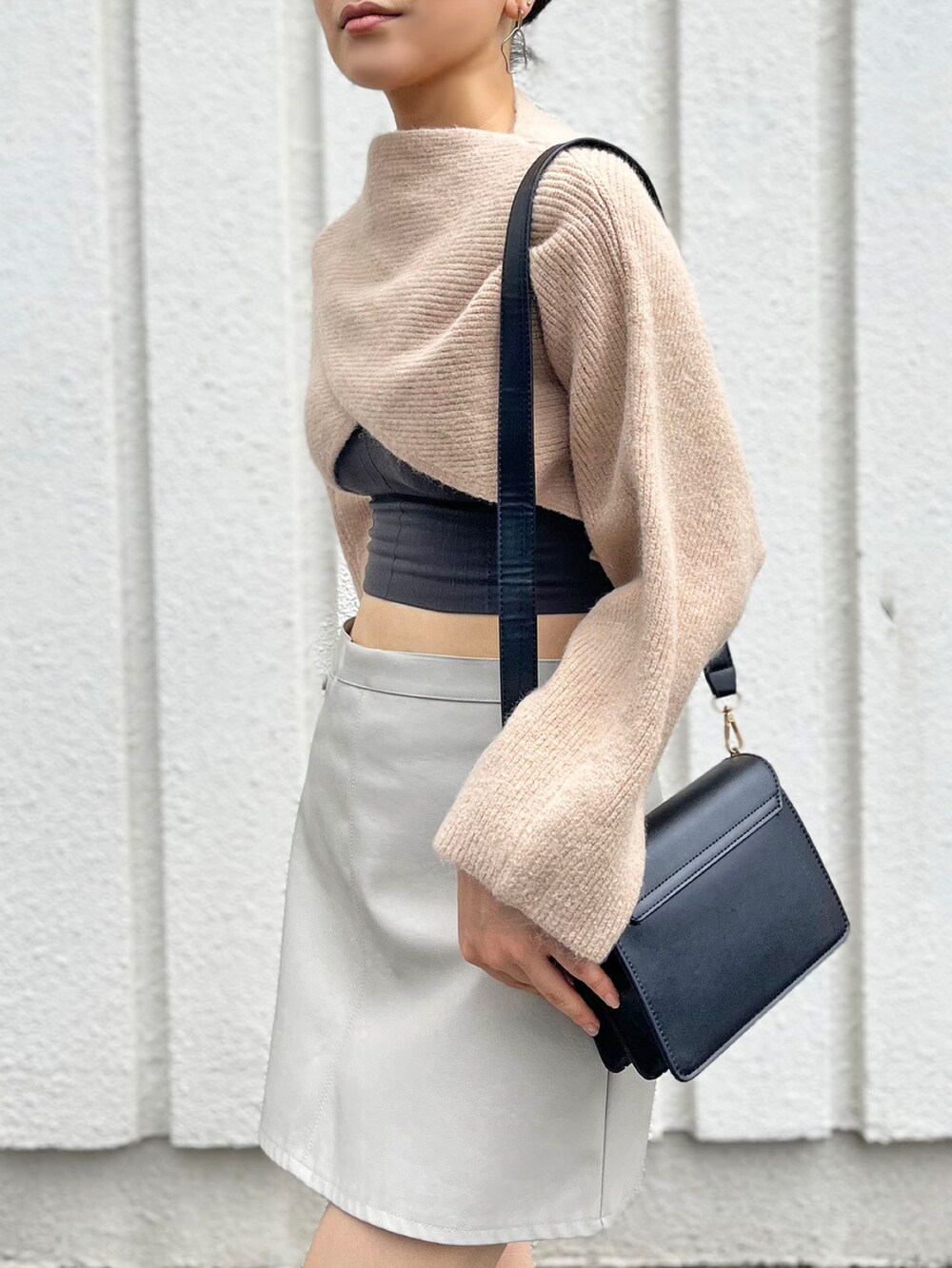 ベージュ系のニット/セーター、ブラック系のキャミソール、ブラック系のショルダーバッグを着用したレディースの秋コーディネートの4枚目の写真