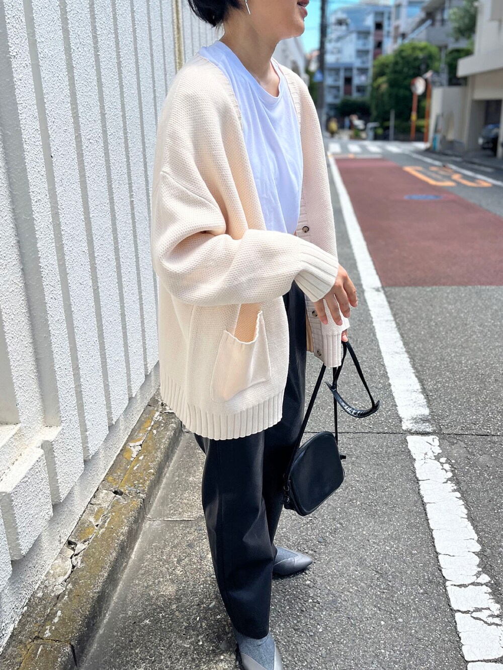 ホワイト系のカーディガン/ボレロ、ホワイト系のTシャツ/カットソー、ブラック系のその他パンツを着用したレディースの秋コーディネートの3枚目の写真