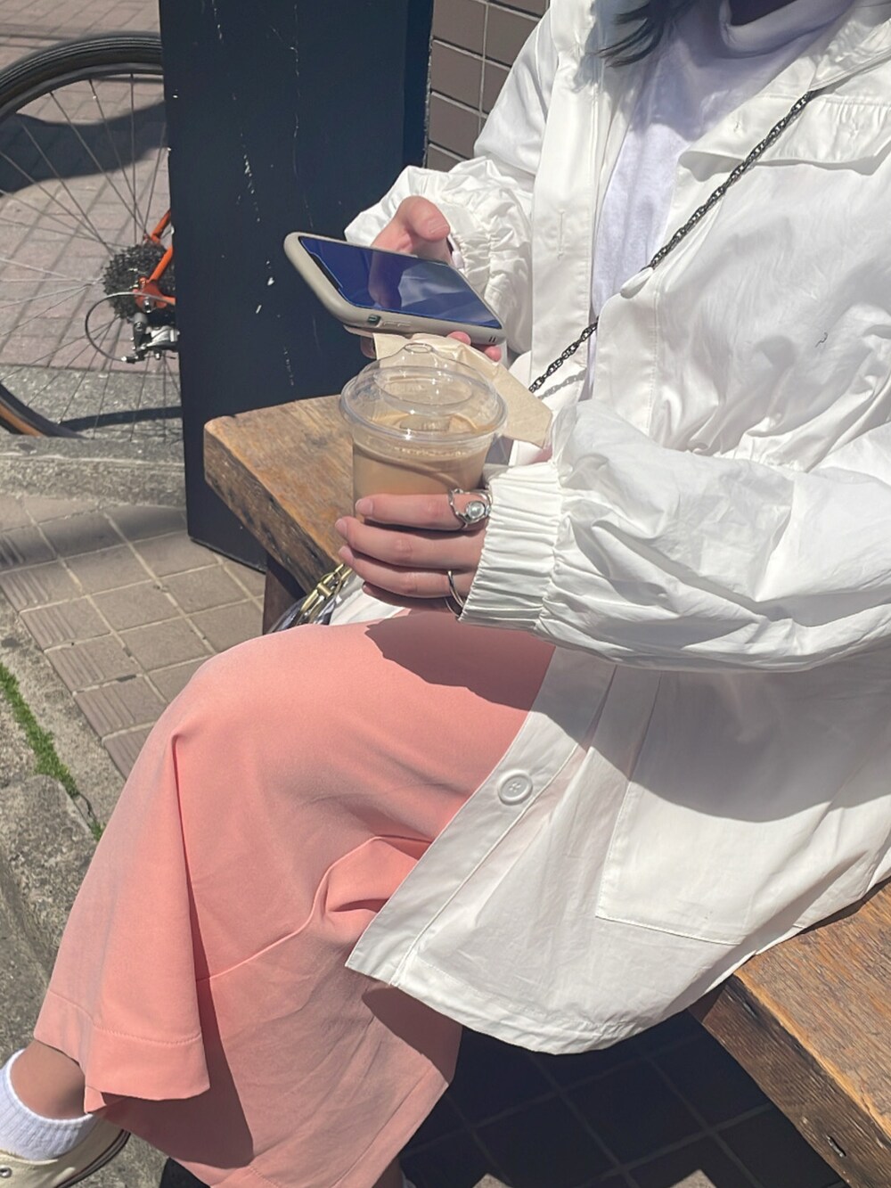 ピンク系のスカート、ホワイト系のブルゾン、ホワイト系のTシャツ/カットソーを着用したレディースの冬コーディネートの2枚目の写真