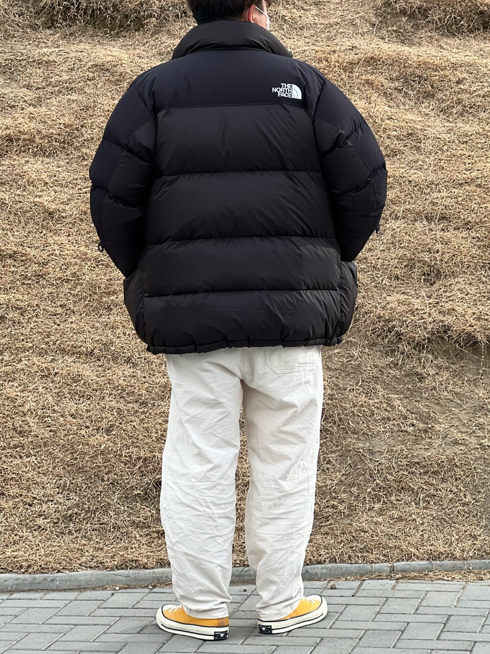 ホワイト系のその他パンツ、ベージュ系のその他トップス、ブラック系のダウンジャケット/コートを着用したメンズの冬コーディネートの2枚目の写真
