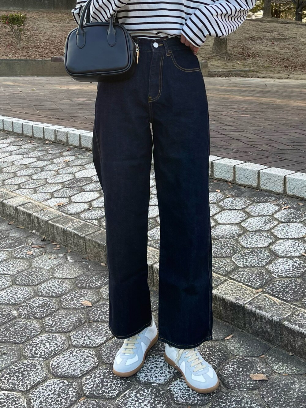 ホワイト系のTシャツ/カットソー、ブラック系のカーディガン/ボレロ、ブルー系のデニムパンツを着用したレディースの冬コーディネートの3枚目の写真