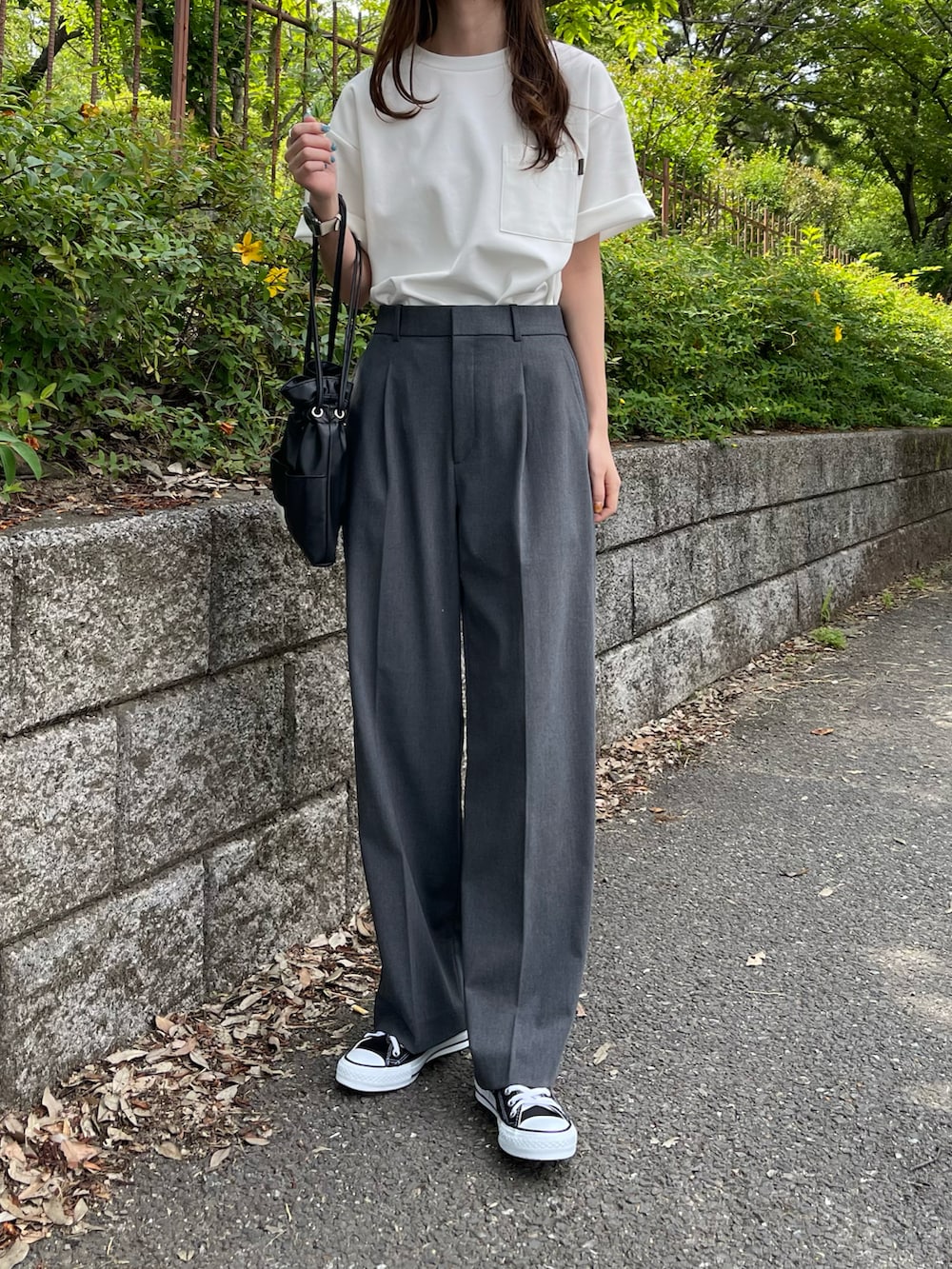 ホワイト系のTシャツ/カットソー、グレー系のパンツ、ブラック系のスニーカーを着用したレディースの夏コーディネートの2枚目の写真