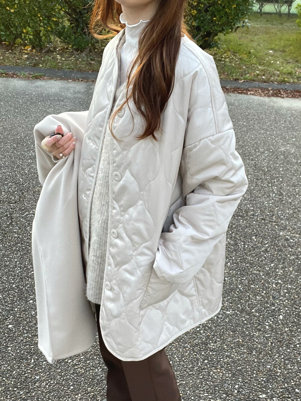ホワイト系のノーカラーコート、ホワイト系のニット/セーター、ホワイト系のTシャツ/カットソーを着用したレディースの秋コーディネートの5枚目の写真