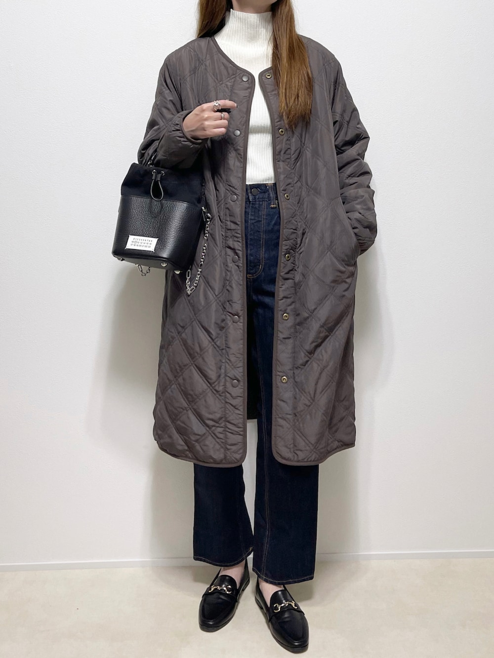 グレー系のその他アウター、ホワイト系のニット/セーター、ブルー系のデニムパンツを着用したレディースの秋コーディネートの2枚目の写真