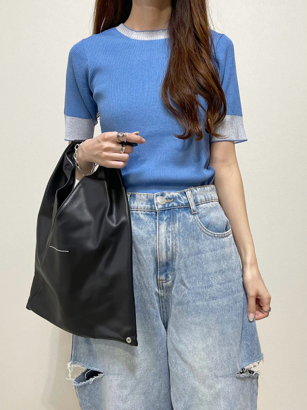 ブルー系のニット/セーター、ブルー系のデニムパンツ、ブラック系のサンダルを着用したレディースの夏コーディネートの3枚目の写真