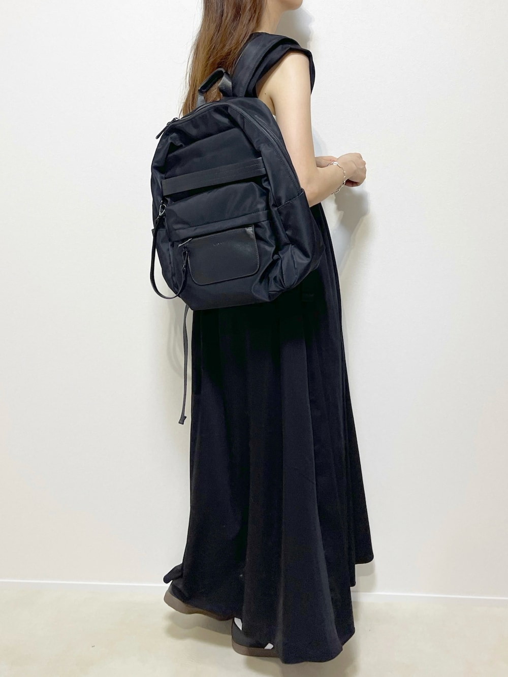 ブラック系のワンピース/ドレス、ブラック系のスニーカー、ブラック系のバックパック/リュックを着用したレディースの夏コーディネートの3枚目の写真