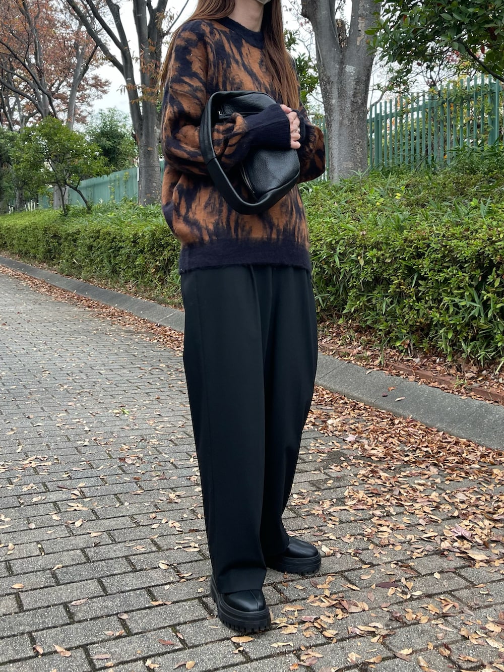 ブラウン系のニット/セーター、ブラック系のパンツ、ブラック系のブーツを着用したレディースの秋コーディネートの3枚目の写真