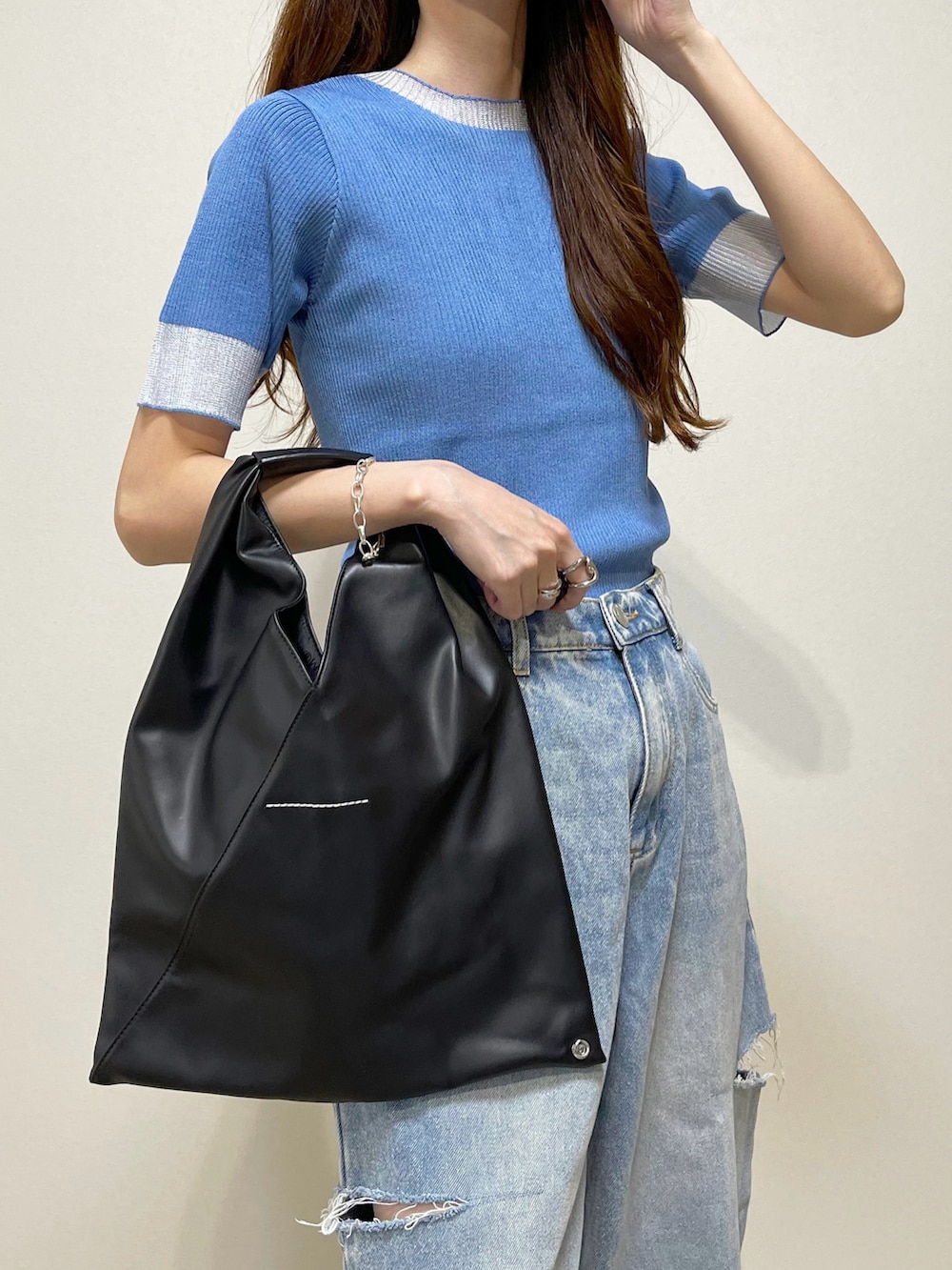 ブルー系のニット/セーター、ブルー系のデニムパンツ、ブラック系のサンダルを着用したレディースの夏コーディネートの4枚目の写真