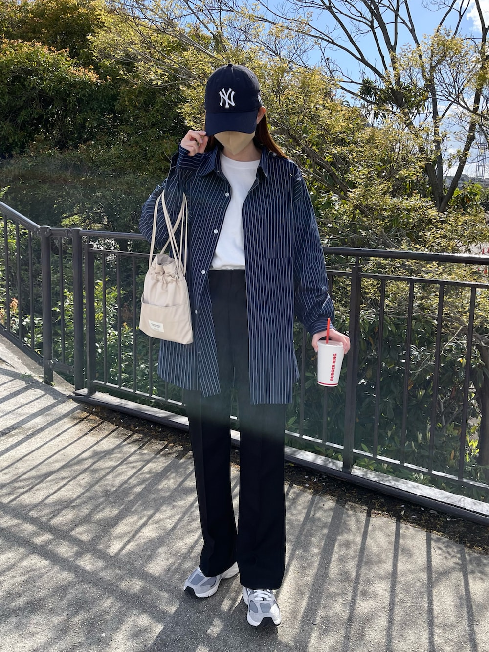 ブルー系のシャツ/ブラウス、ホワイト系のTシャツ/カットソー、ブラック系のスラックスを着用したレディースの春コーディネートの2枚目の写真