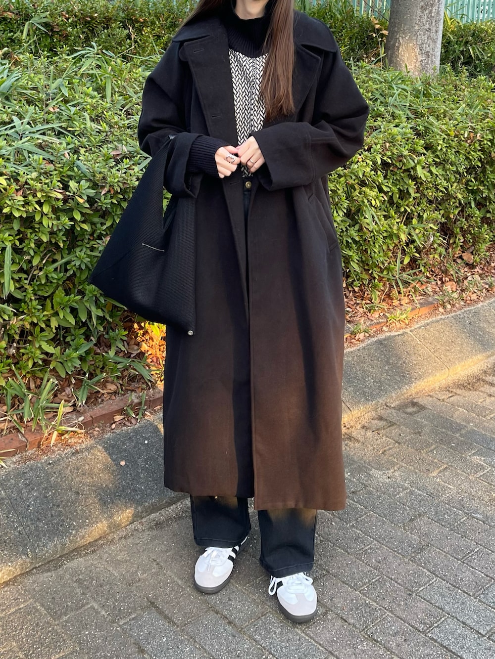 ブラック系のその他アウター、ホワイト系のニット/セーター、ブラック系のデニムパンツを着用したレディースの冬コーディネートの3枚目の写真