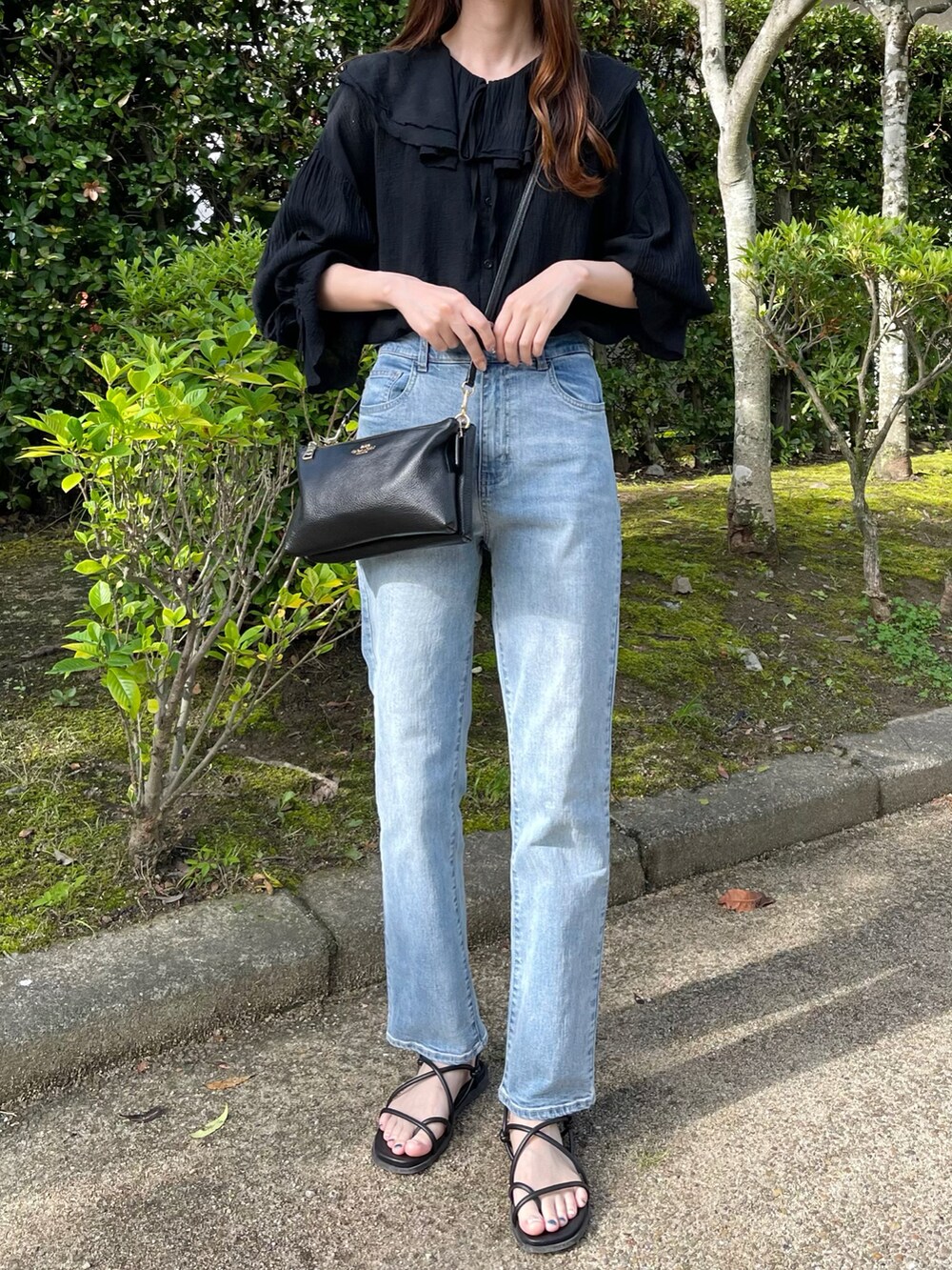 ブラック系のシャツ/ブラウス、ブルー系のデニムパンツ、ブラック系のサンダルを着用したレディースの夏コーディネートの2枚目の写真