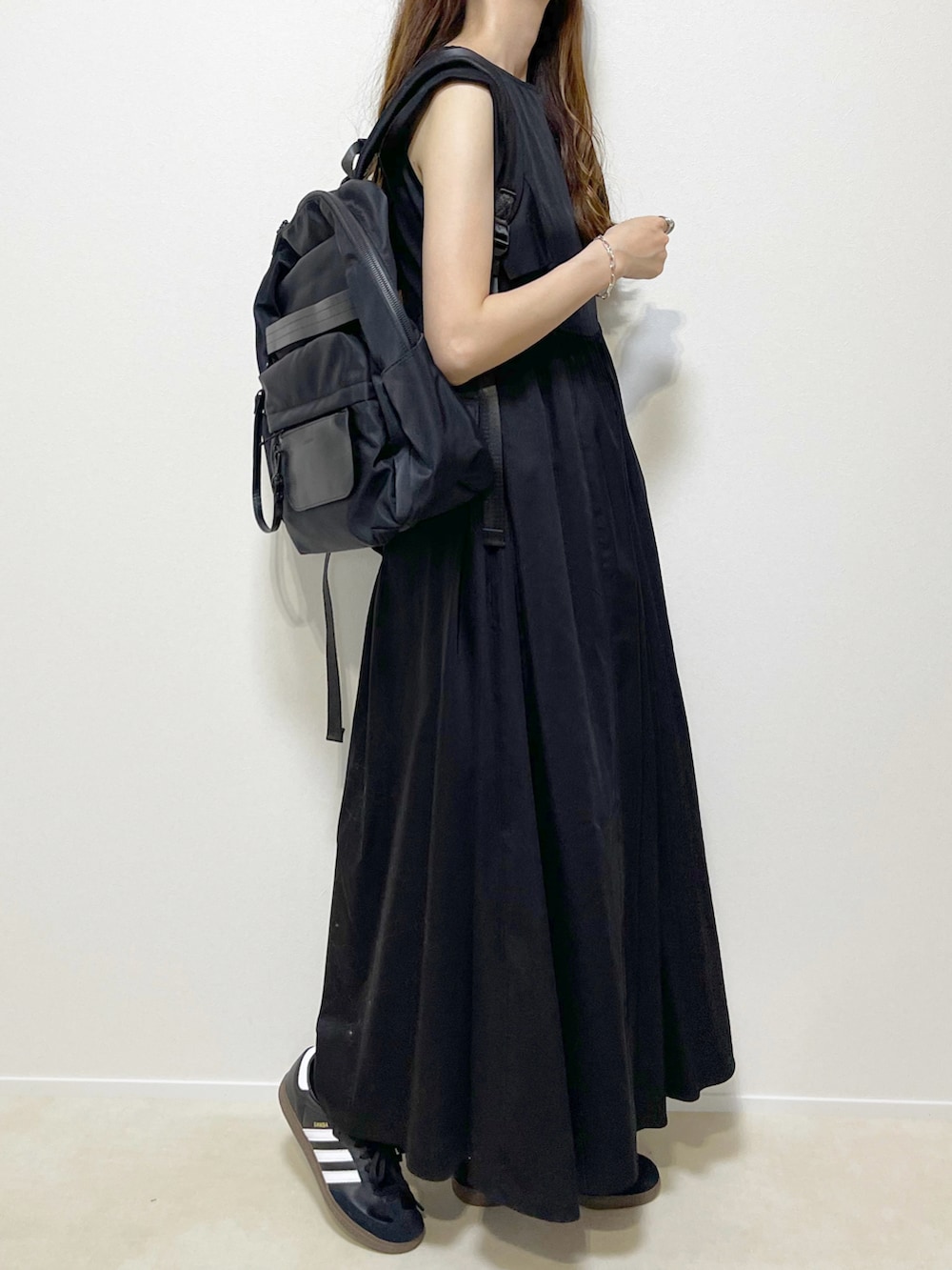 ブラック系のワンピース/ドレス、ブラック系のスニーカー、ブラック系のバックパック/リュックを着用したレディースの夏コーディネートの2枚目の写真