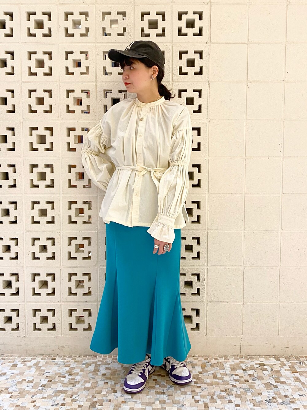 パープル系のスニーカー、グリーン系のスカート、ベージュ系のシャツ/ブラウスを着用したレディースの冬コーディネートの2枚目の写真