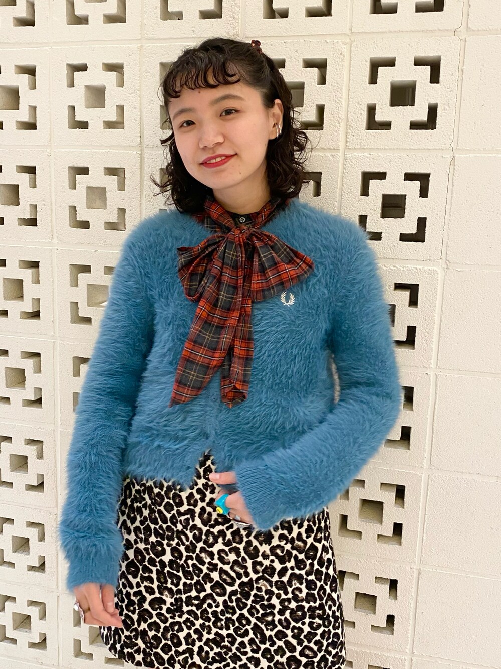 ブラック系のブーツ、ブラック系のスカート、ブルー系のカーディガン/ボレロを着用したレディースの秋コーディネートの2枚目の写真