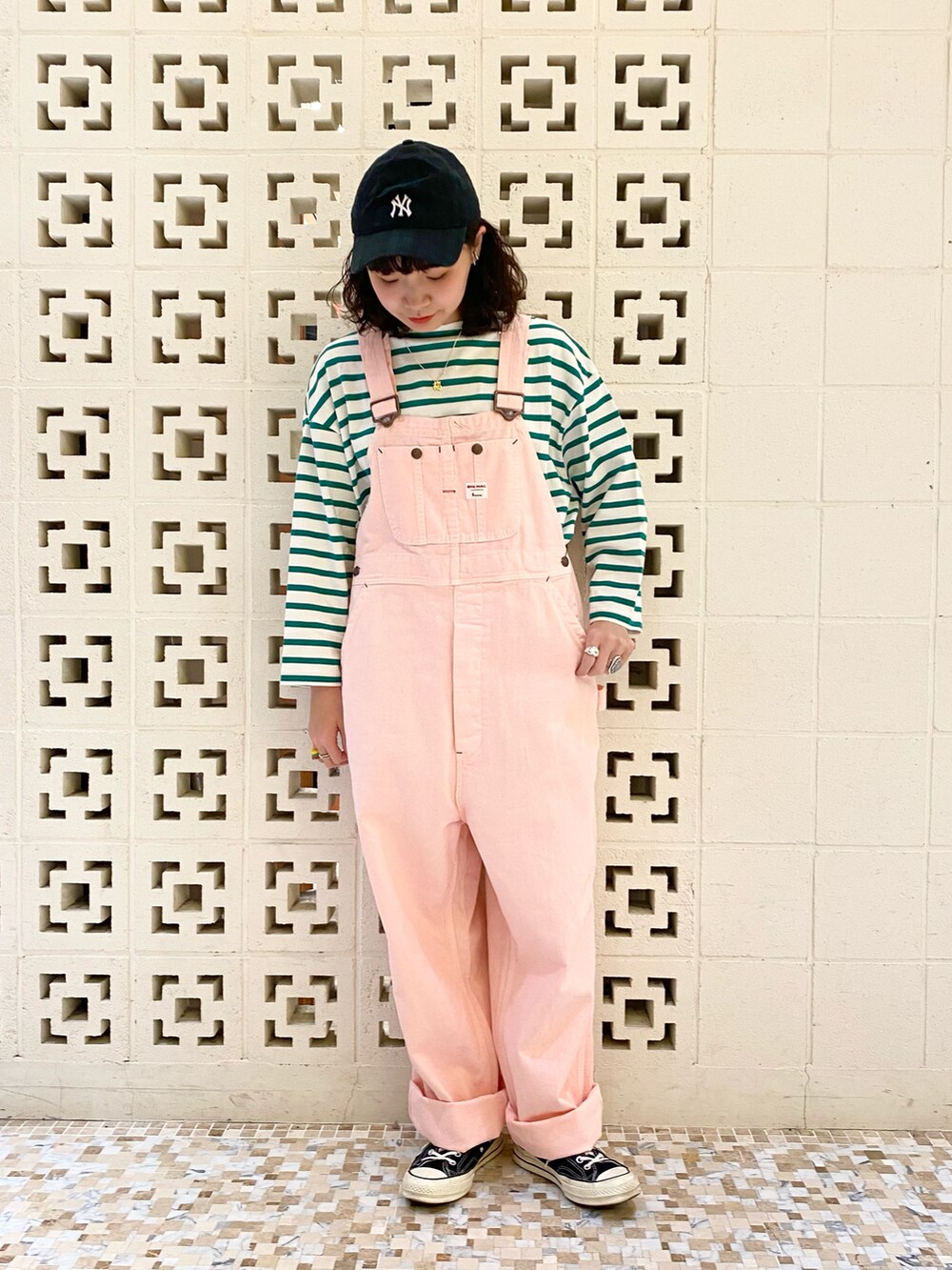 ブラック系のスニーカー、ピンク系のサロペット/オーバーオール、ホワイト系のTシャツ/カットソーを着用したレディースの冬コーディネートの3枚目の写真