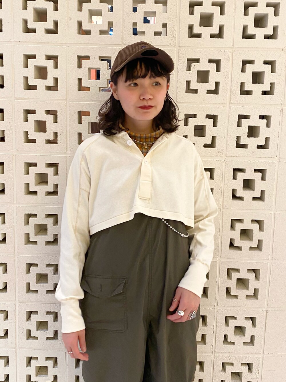 グリーン系のスニーカー、グリーン系のサロペット/オーバーオール、レッド系のトートバッグを着用したレディースの冬コーディネートの3枚目の写真