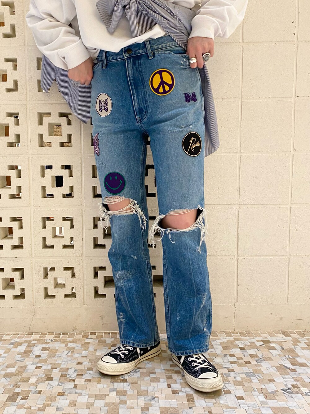 ブラック系のスニーカー、ブルー系のパンツ、ホワイト系のTシャツ/カットソーを着用したレディースの春コーディネートの4枚目の写真