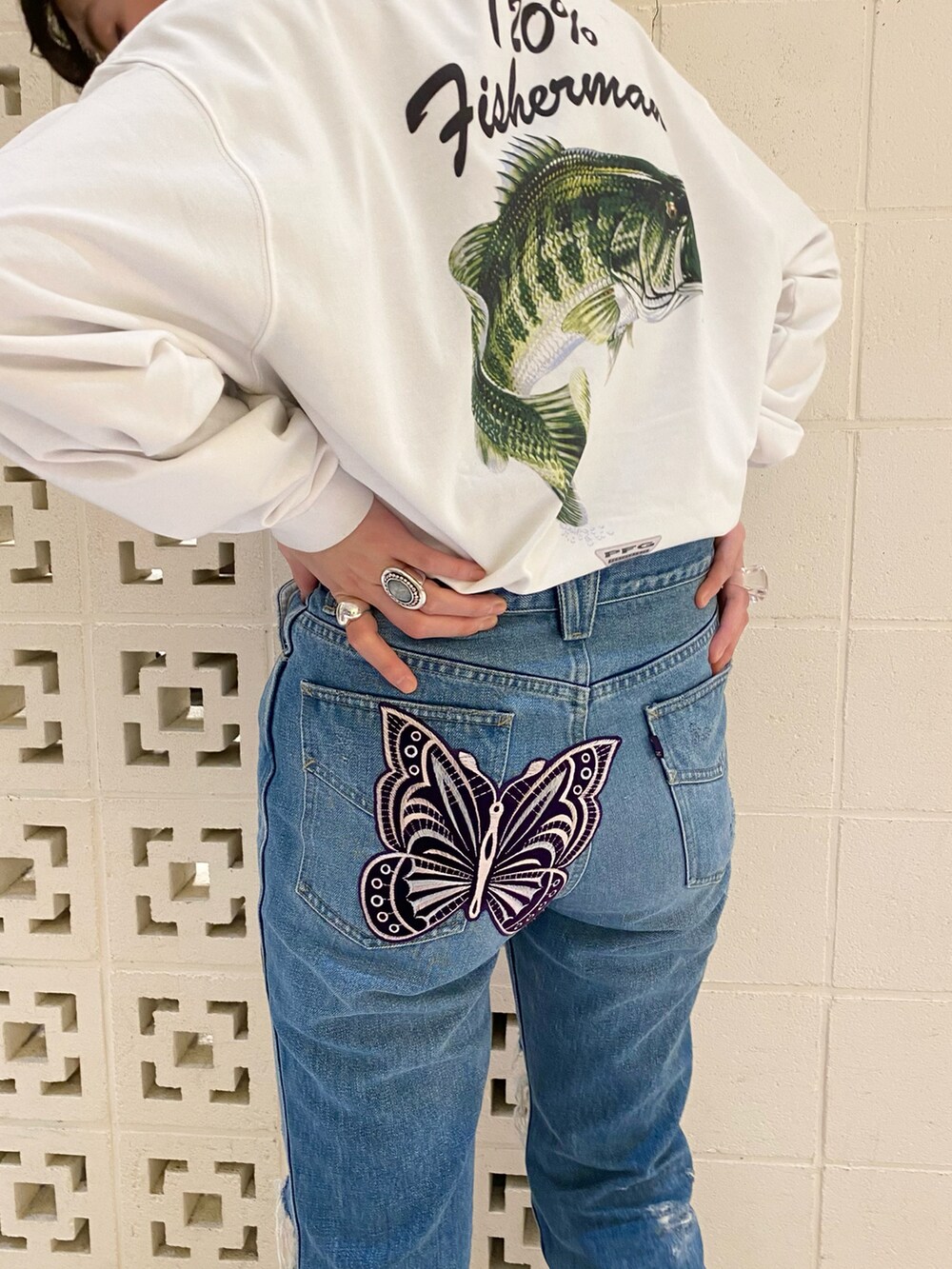 ブラック系のスニーカー、ブルー系のパンツ、ホワイト系のTシャツ/カットソーを着用したレディースの春コーディネートの3枚目の写真