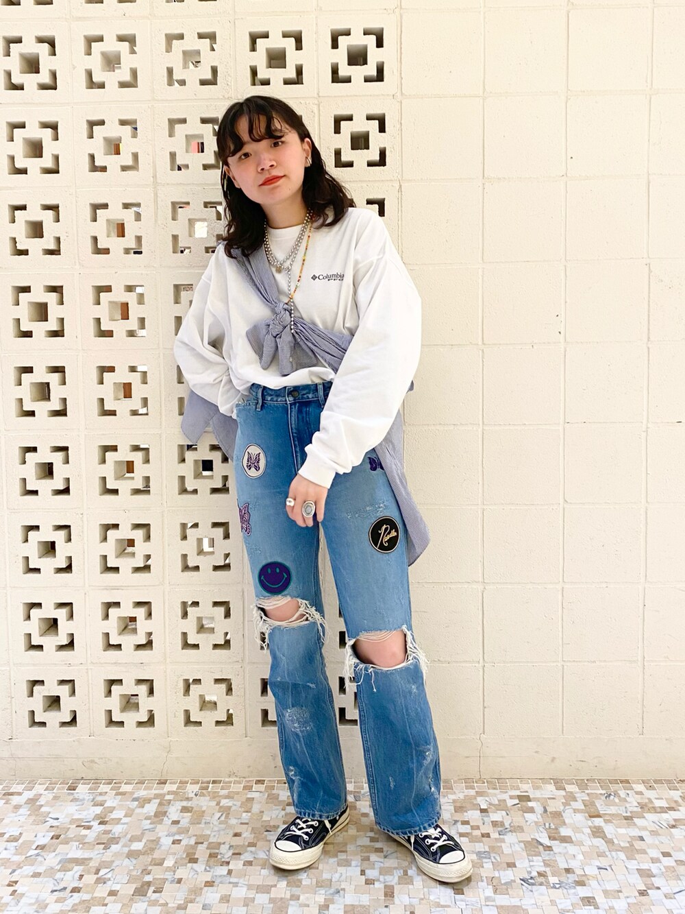 ブラック系のスニーカー、ブルー系のパンツ、ホワイト系のTシャツ/カットソーを着用したレディースの春コーディネートの2枚目の写真