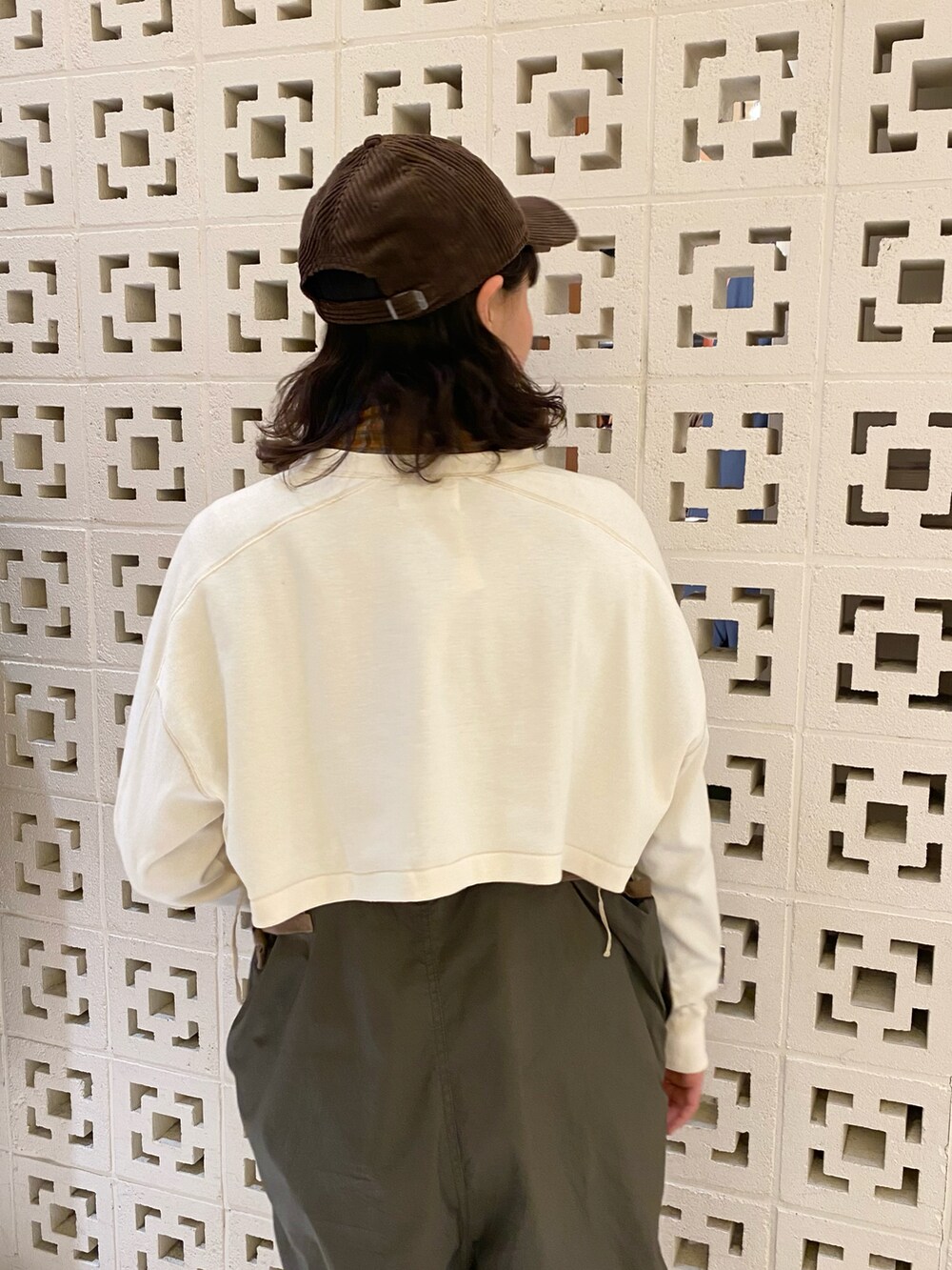 グリーン系のスニーカー、グリーン系のサロペット/オーバーオール、レッド系のトートバッグを着用したレディースの冬コーディネートの4枚目の写真