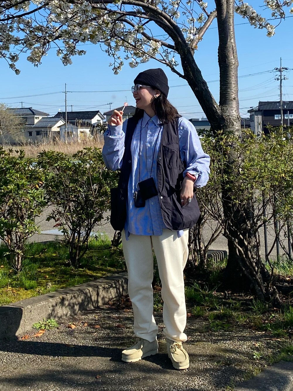 ベージュ系のブーツ、ブルー系のシャツ/ブラウス、ブラック系のベストを着用したレディースの春コーディネートの2枚目の写真