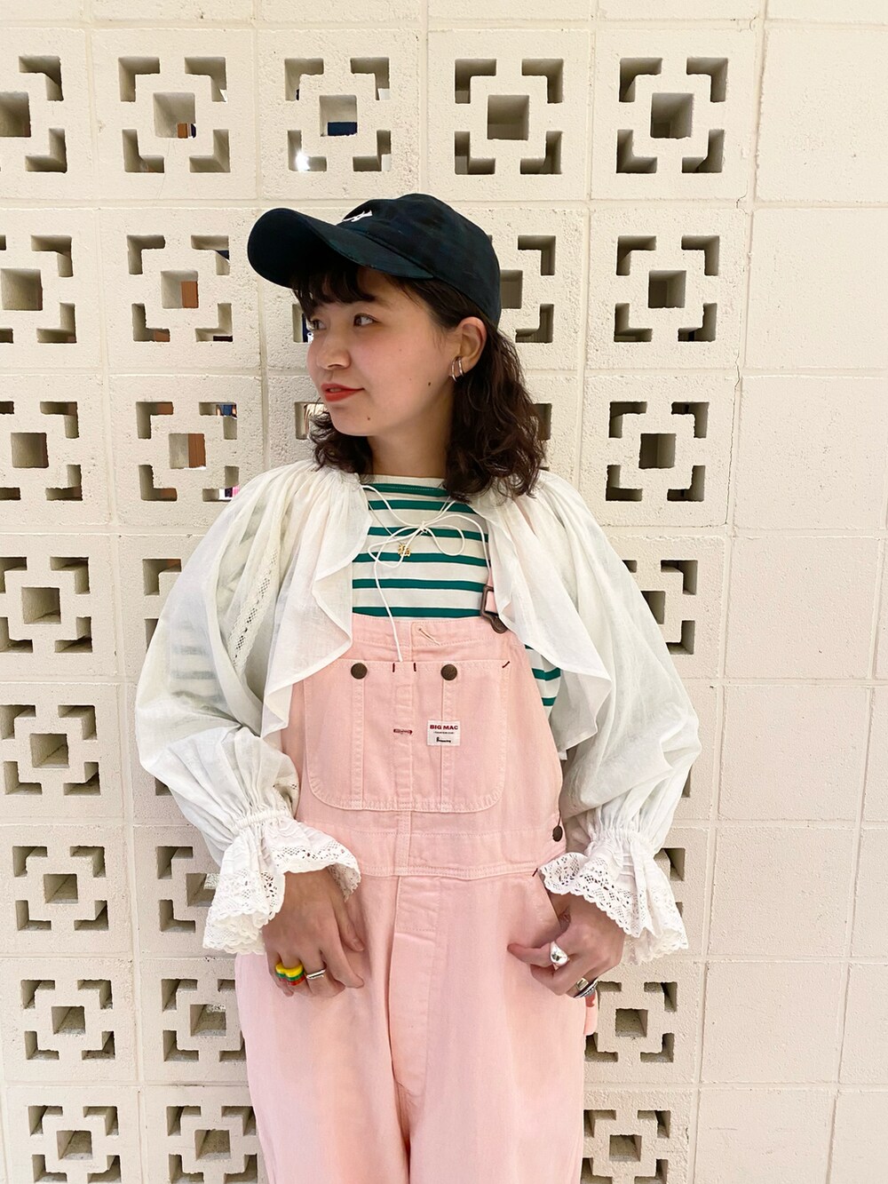 ブラック系のスニーカー、ピンク系のサロペット/オーバーオール、ホワイト系のTシャツ/カットソーを着用したレディースの冬コーディネートの4枚目の写真