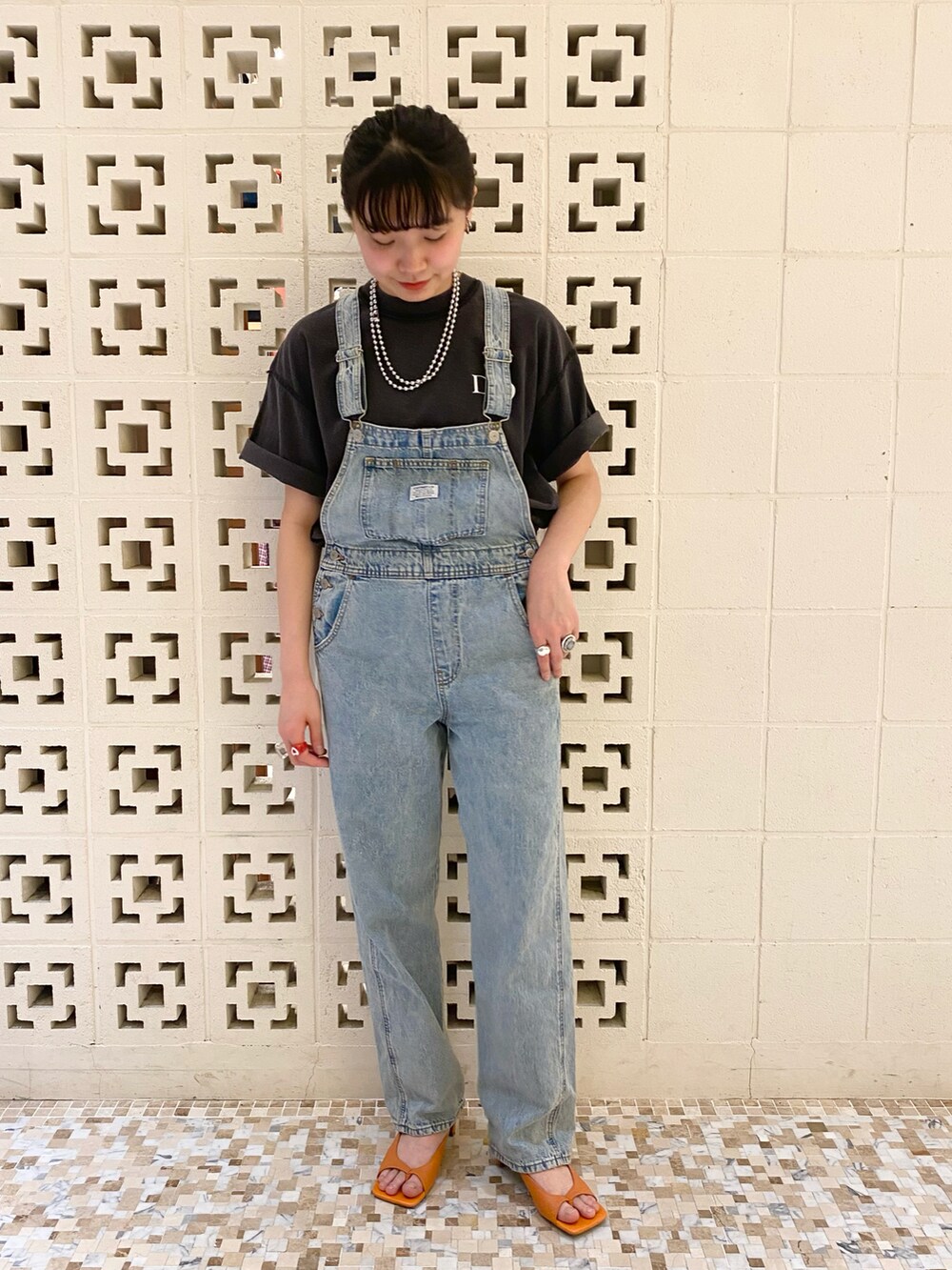 オレンジ系のサンダル、ブルー系のサロペット/オーバーオール、ブラック系のその他トップスを着用したレディースの春コーディネートの3枚目の写真