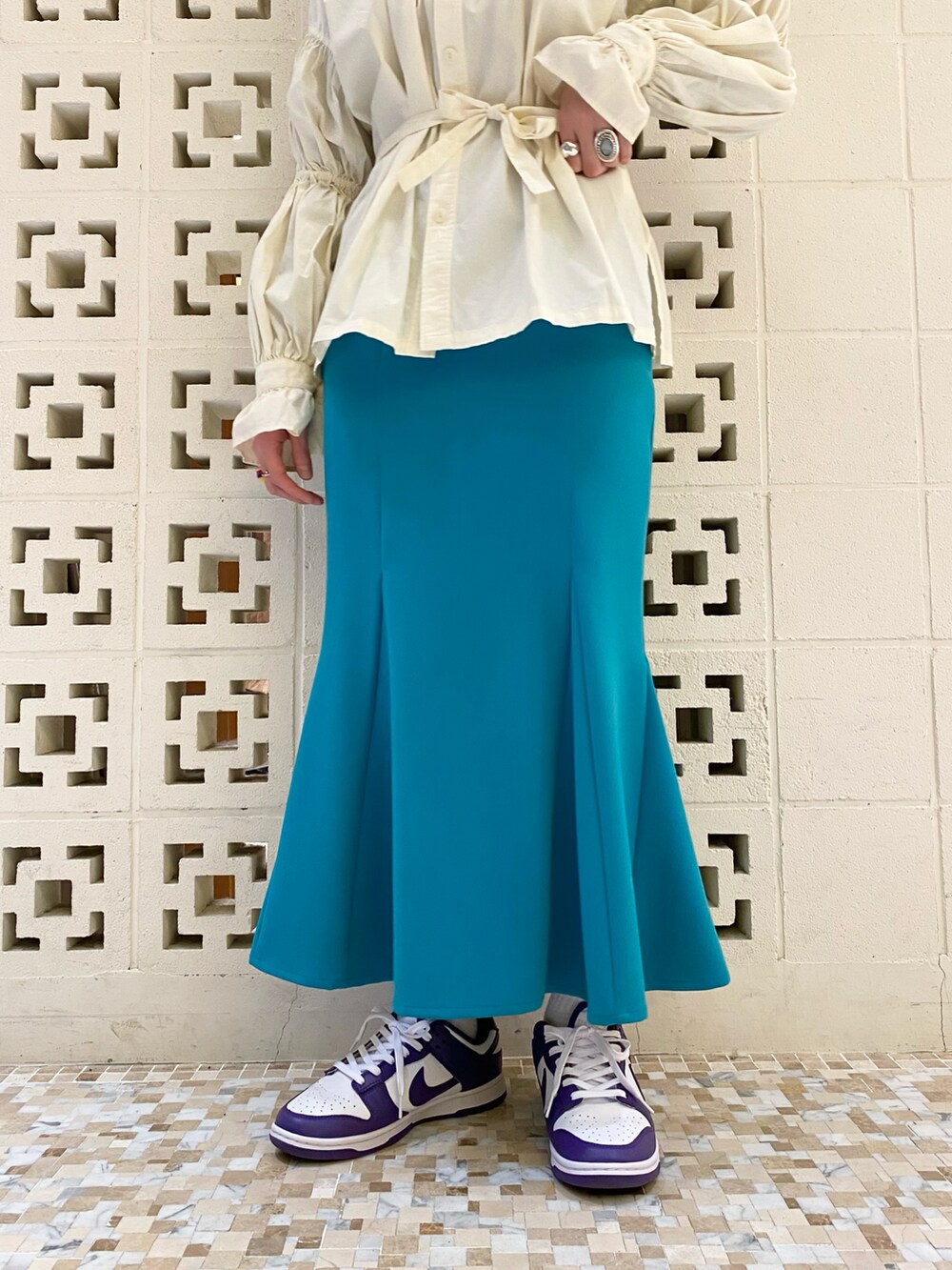 パープル系のスニーカー、グリーン系のスカート、ベージュ系のシャツ/ブラウスを着用したレディースの冬コーディネートの4枚目の写真