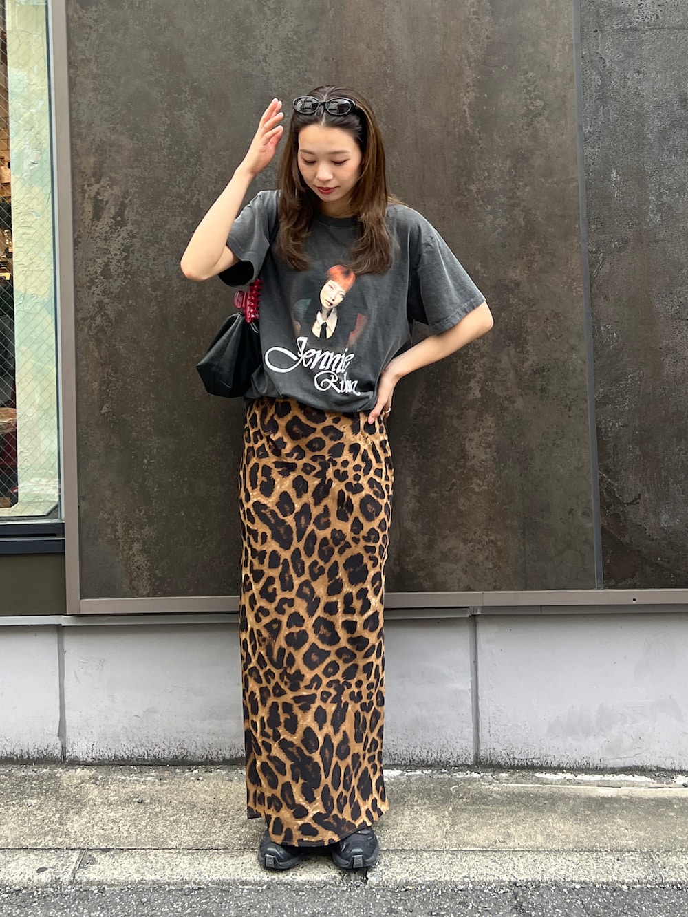 ブラック系のスニーカー、ブラック系のTシャツ/カットソー、ブラック系のショルダーバッグを着用したレディースの夏コーディネートの2枚目の写真