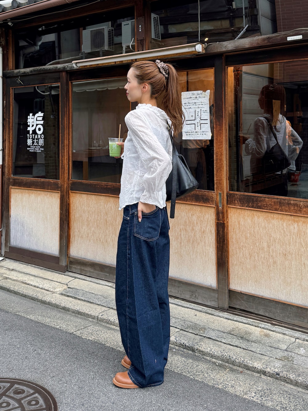 ホワイト系のシャツ/ブラウス、ブルー系のデニムパンツ、ブラウン系のブーツを着用したレディースの秋コーディネートの2枚目の写真