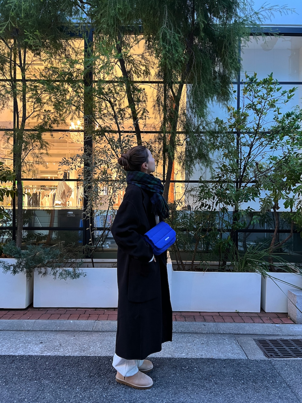 グレー系のスウェット、ブラック系のチェスターコート、グレー系のスウェットパンツを着用したレディースの冬コーディネートの2枚目の写真