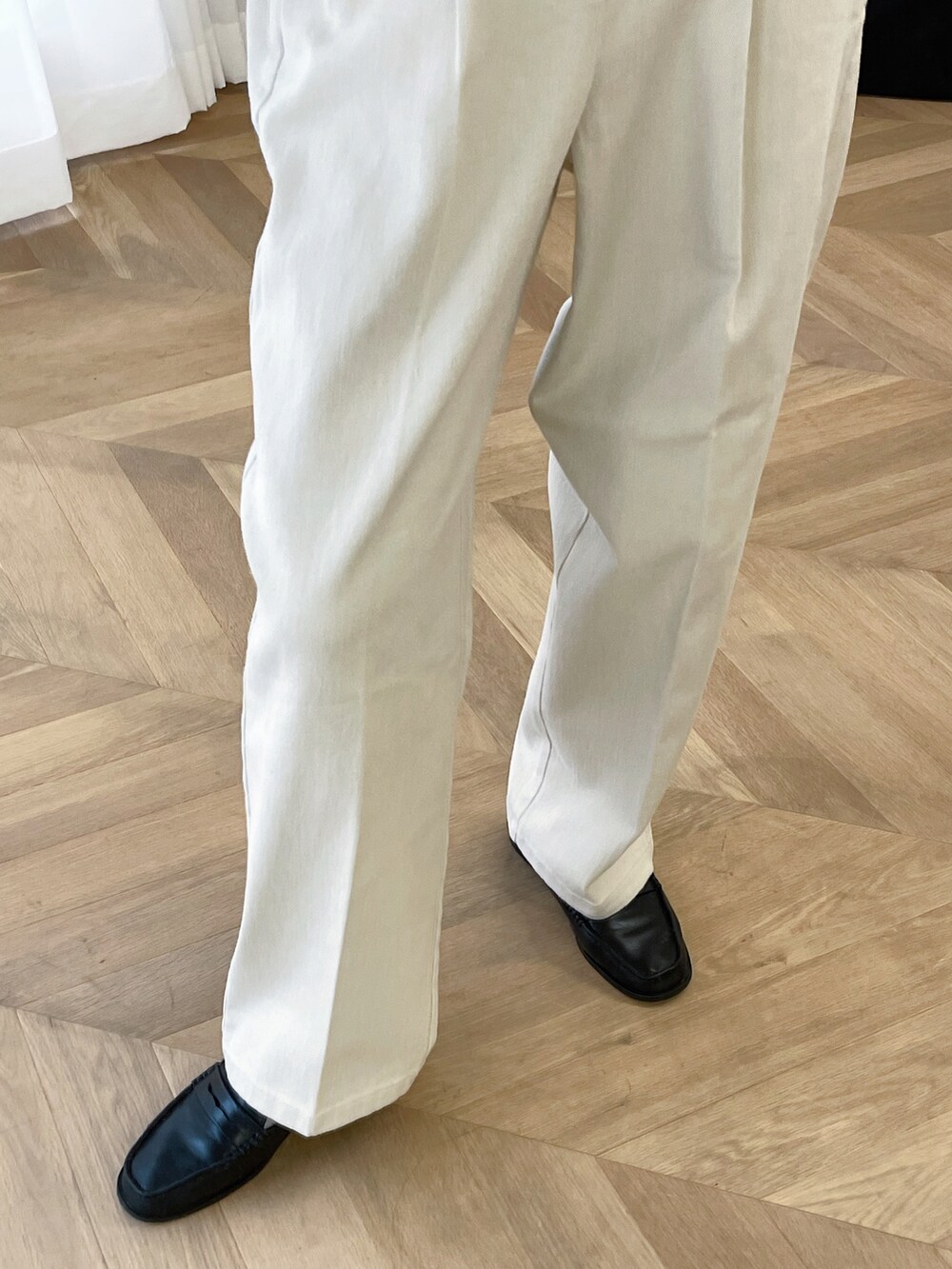 グレー系のカーディガン/ボレロ、ホワイト系のショルダーバッグ、ホワイト系のチノパンツを着用したレディースの秋コーディネートの3枚目の写真