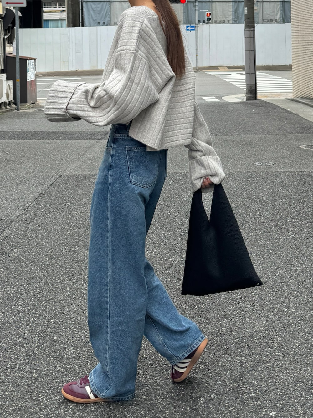 ホワイト系のニット/セーター、ブルー系のデニムパンツ、レッド系のスニーカーを着用したレディースの秋コーディネートの4枚目の写真